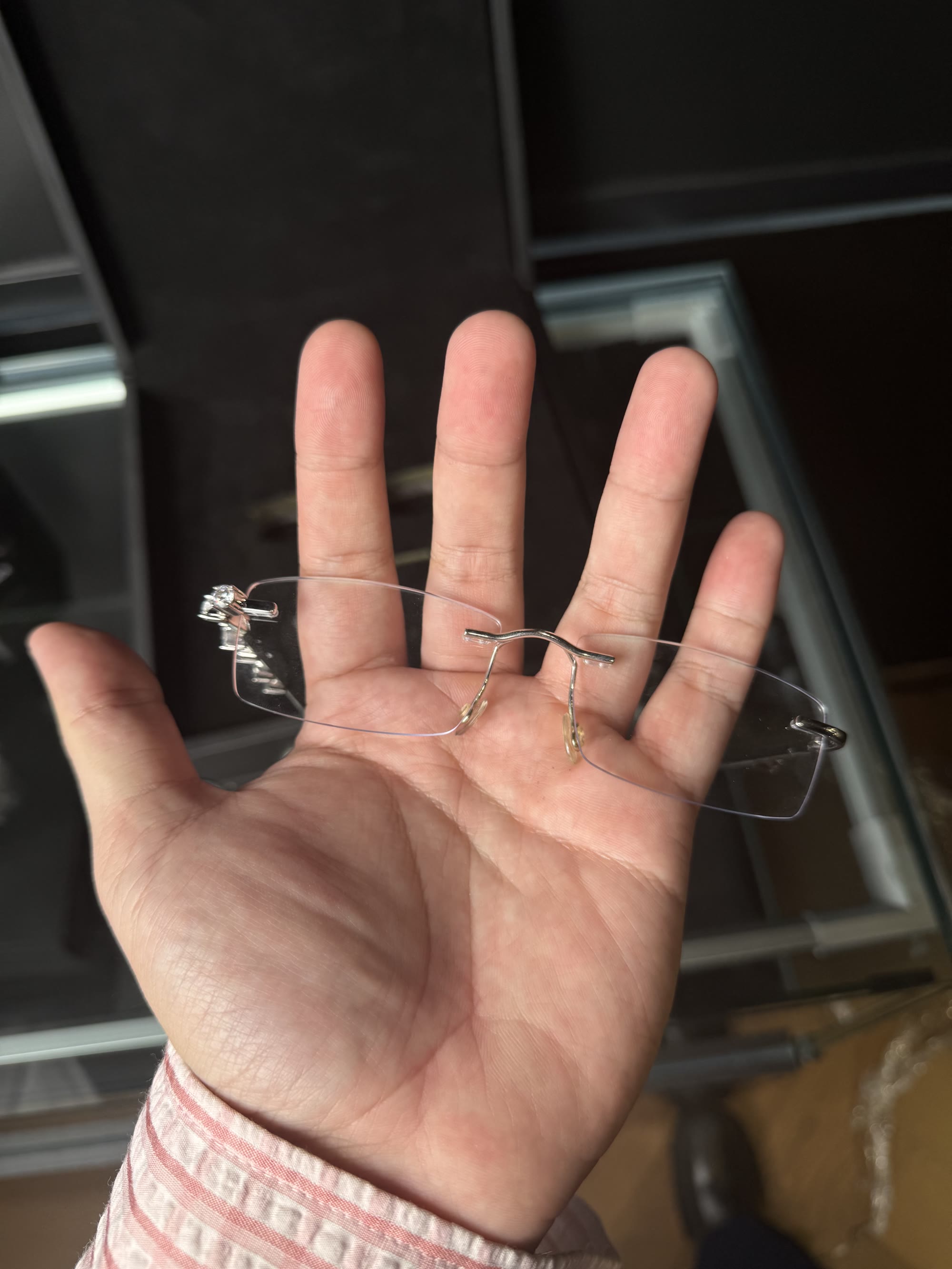 The rimless frame held front-on in an open palm, almost invisible