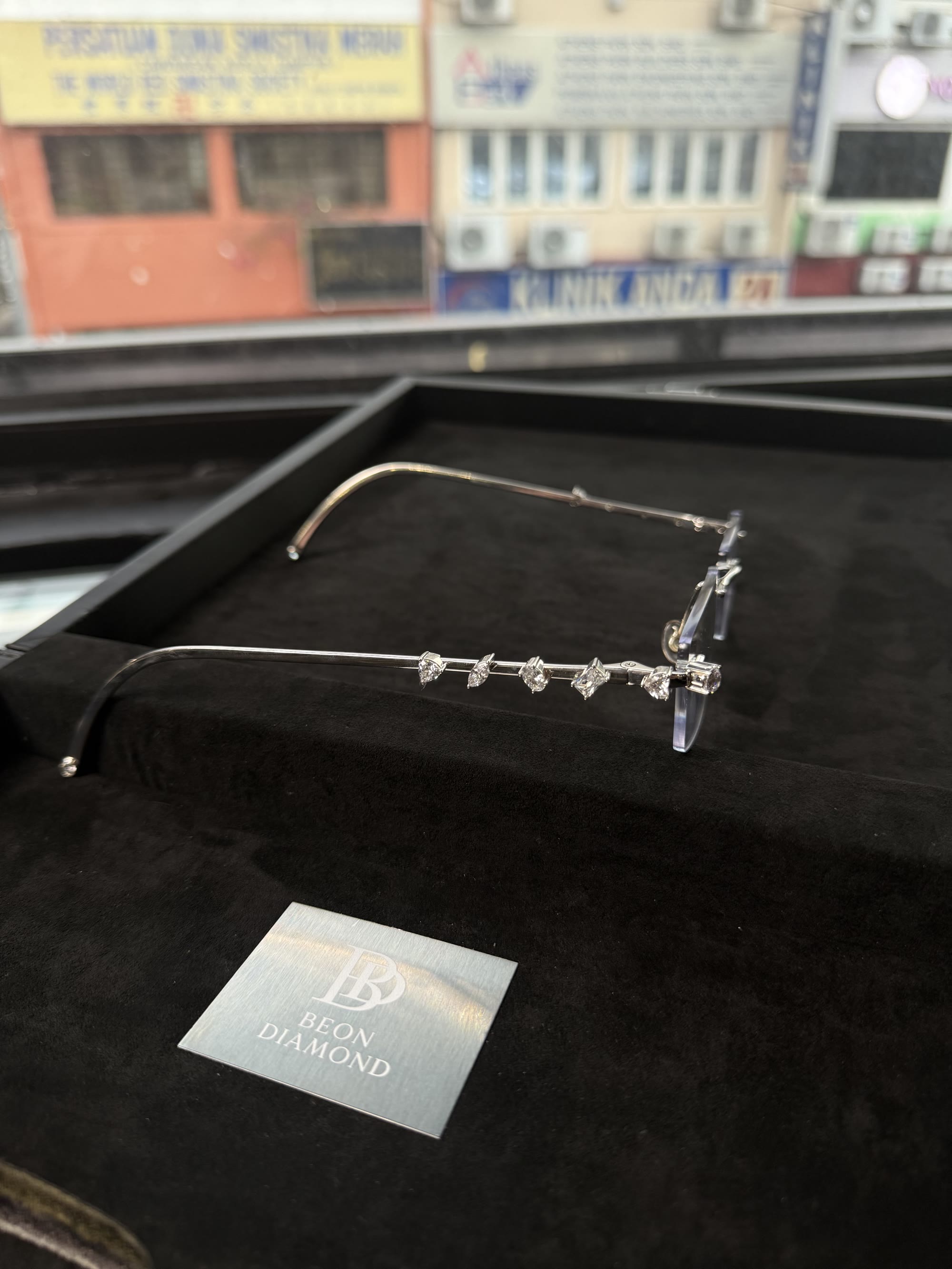 Side profile of the arm, six diamonds in a row, Kuala Lumpur shophouses behind