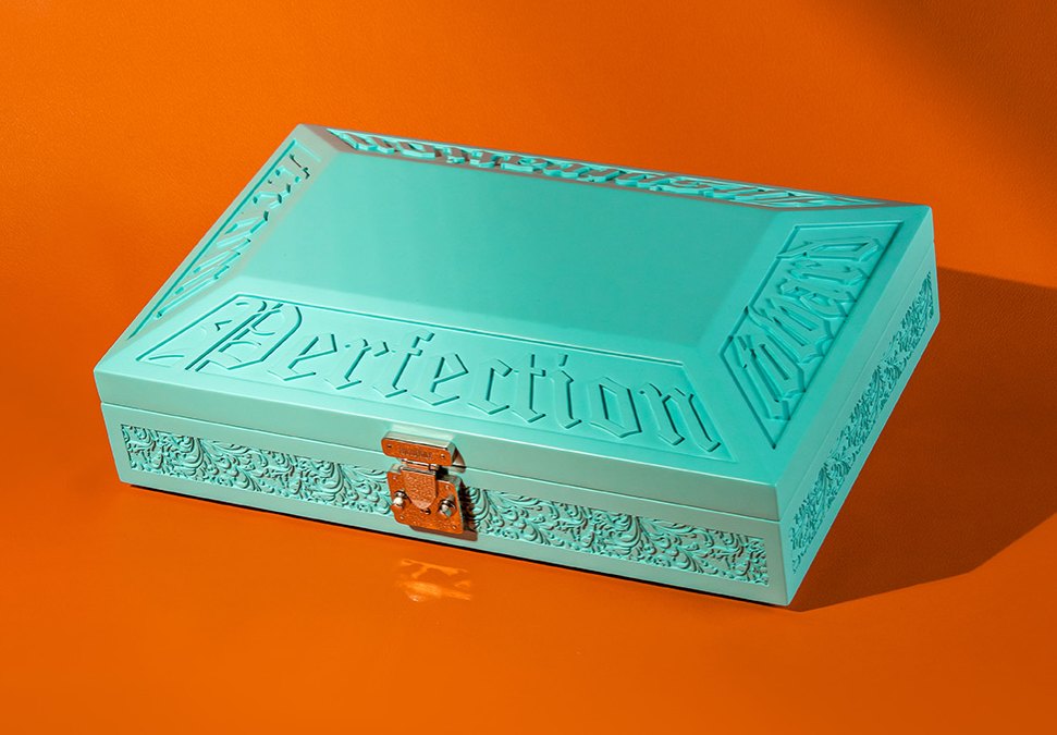 A real box with carved relief lettering and scrollwork in one colour